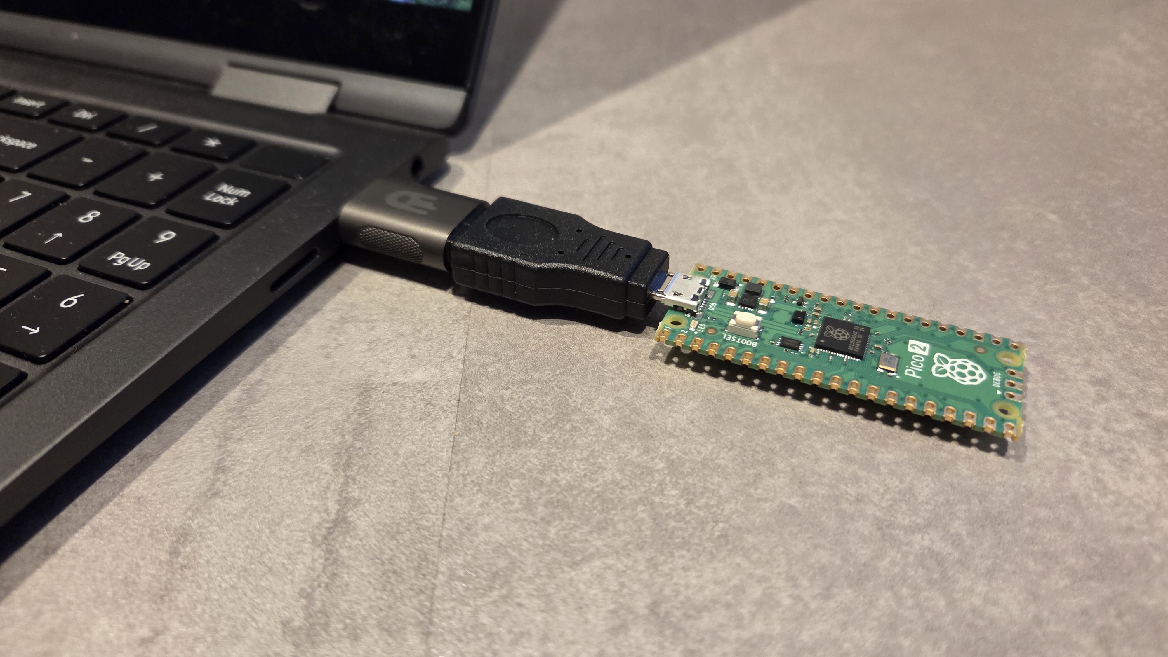 Compact setup: Pico 2 connected to laptop using male-to-male USB adapter